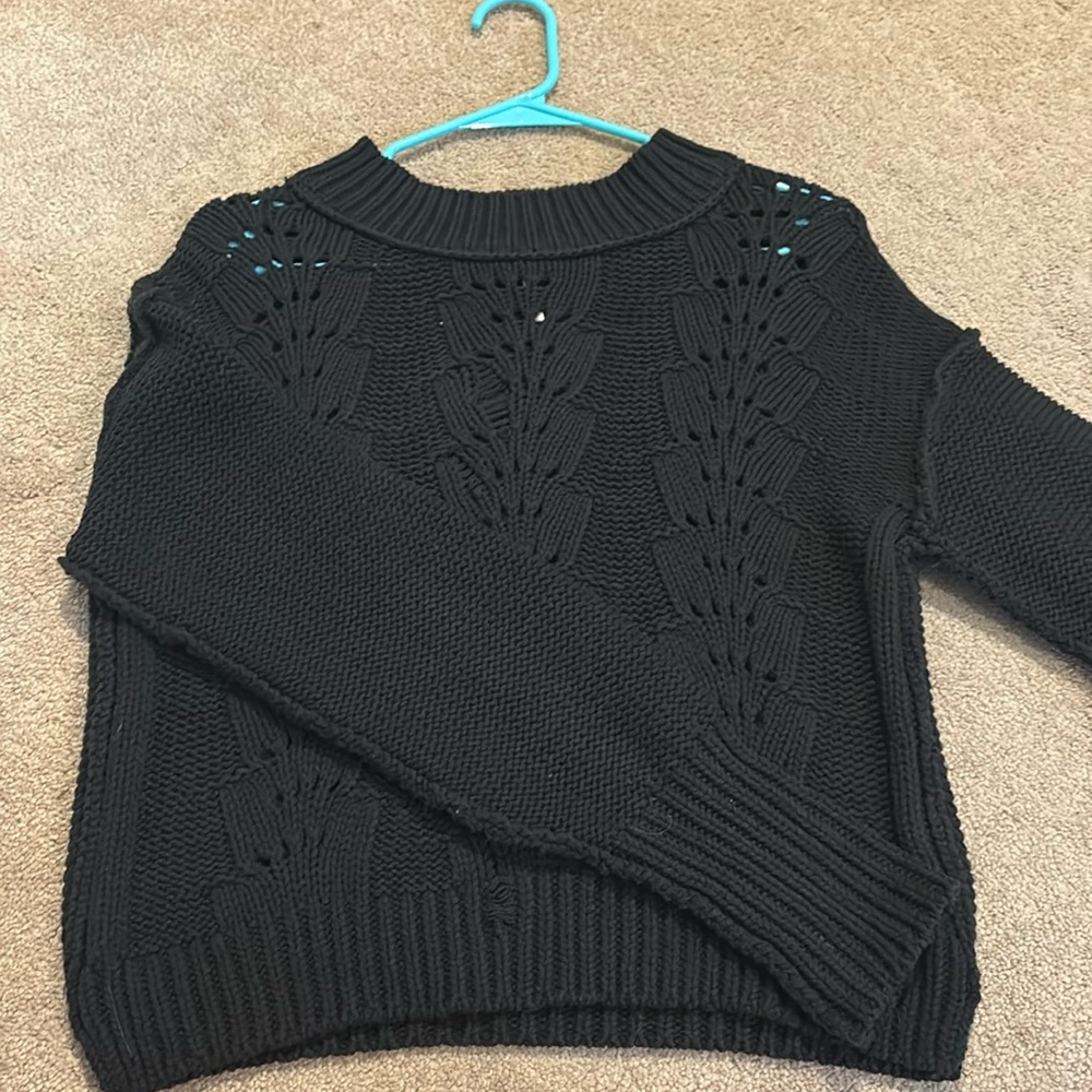 Black sweater with a hole-ish design in the front